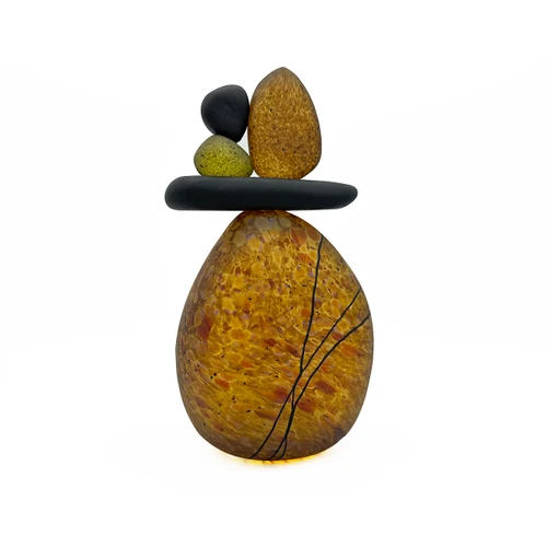 Back view of blown glass cairn sculpture by Melanie Leppla with four glass stones stacked on top of a speckled amber base
