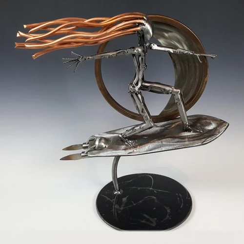 The Surfer sculpture of a steel surfer with flowing copper hair riding under a curling wave by Adam Homan