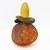 Angled view of blown glass cairn sculpture by Melanie Leppla with three glass stones stacked on top of a speckled amber base