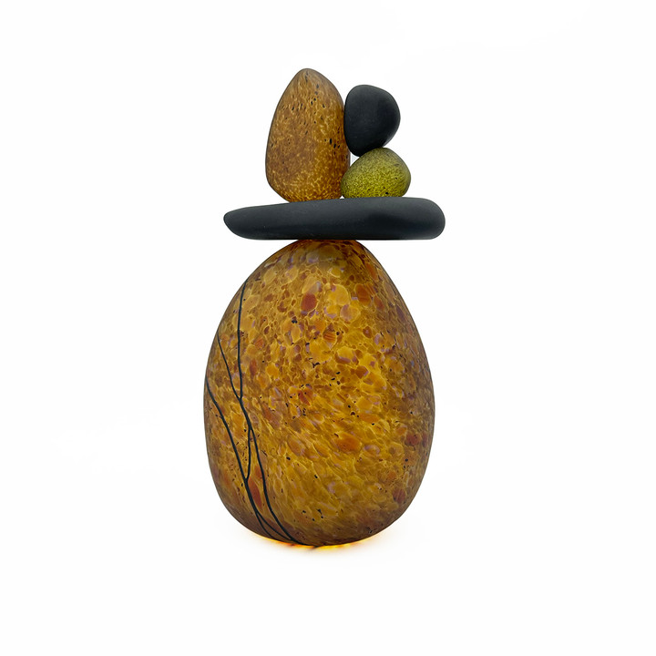 Blown glass cairn sculpture by Melanie Leppla with four glass stones stacked on top of a speckled amber base
