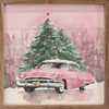 Pink Vintage Car in front of large Christmas trees with pink and red ornaments against a pink sky landscape on Wood Framed Sign