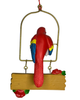 This Christmas ornament features a red, yellow, and blue macaw parrot holding a matching snowcone while perched above a hanging sign that says "It's Just Another Day In Paradise" with flowers