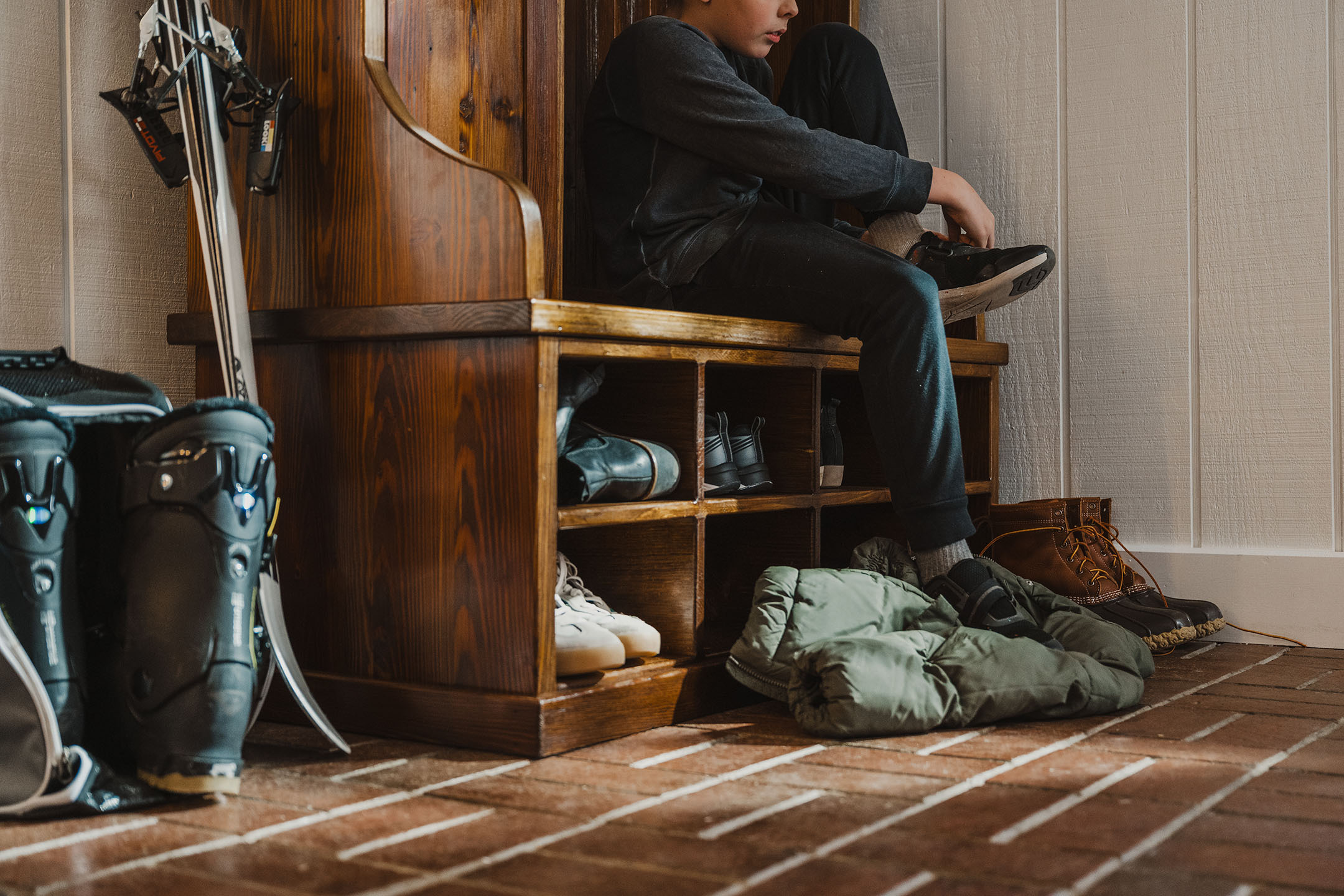 Close-up of mudroom bench with baskets and boots