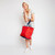 woman holding red nylon tote bag with navy straps on her wrist