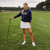 woman wears navy sweatshirt with the word golf embroidered on the front in white cursive text