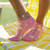 Pair of womens short socks in coral color with cream grid lines and yellow tennis balls stitched on them