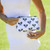 Model holds Small white nylon pouch with navy crossed racquets printed on bag. Pouch has navy racquet zipper.