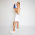 Woman holds small everyday pouch with top zipper. Pouch is blue with light blue racquets printed across the front.