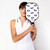 Model holds White base color pickleball paddle with navy and rainbow stiped paddles printed on front. Paddle has navy and blue handle