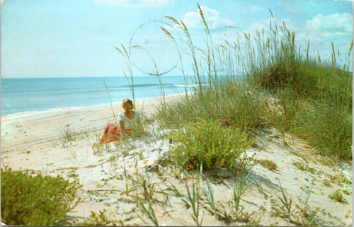 Woman Gazing out at Ocean along Florida sandy beach