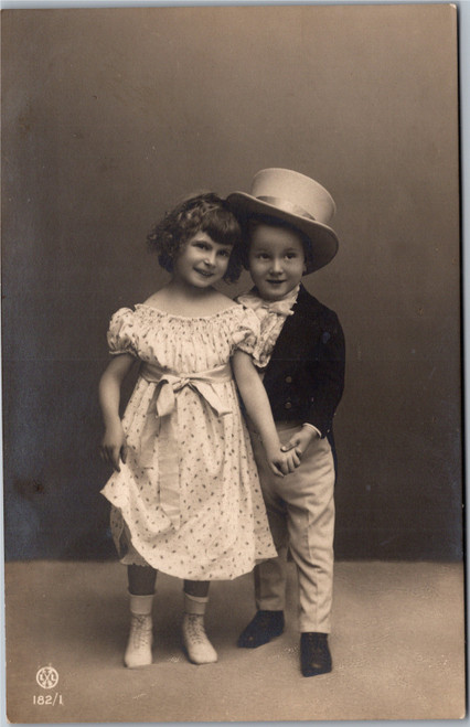 Boy in top hat and tails holding hand of pretty girl in Dress Langebartels