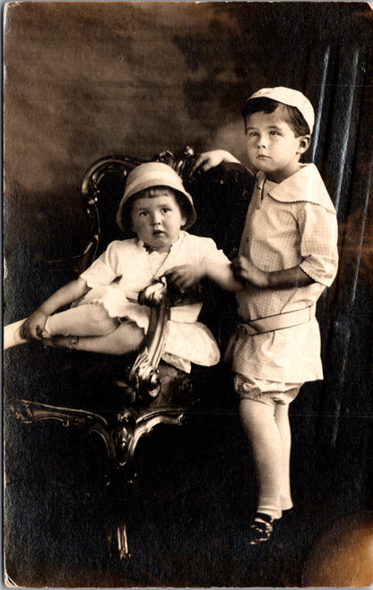 Children in Vintage Outfits on Ornate Chair