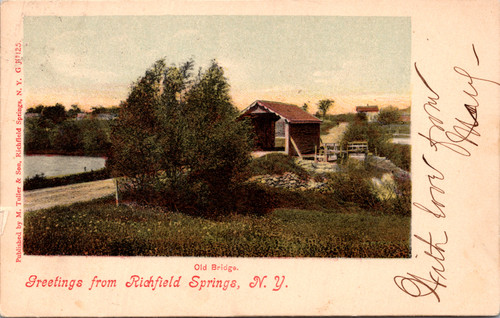 Postcard showing a covered bridge and country road near Richfield Springs New York with trees and fields in the background.
