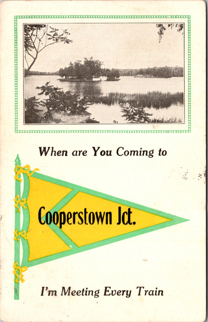Antique divided back postcard with yellow pennant reading Cooperstown Jct and caption When are You Coming to Cooperstown Jct Im Meeting Every Train with black-and-white lake view inset.