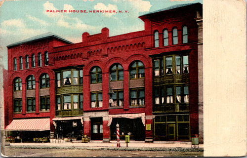 Vintage postcard of the Palmer House in Herkimer New York showing red brick building with storefronts and bay windows.
