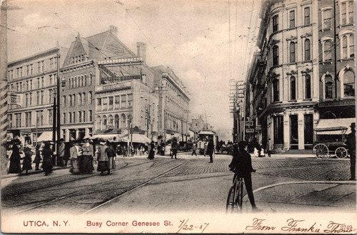 Busy Corner street scene in Utica New York showing buildings, pedestrians, and trolley on Genesee Street.
