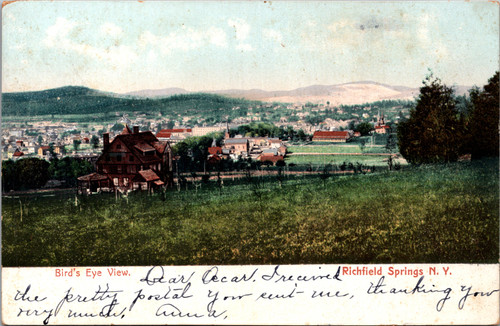 Undivided back postcard showing birds-eye view of Richfield Springs New York with panoramic view of town and surrounding hills.