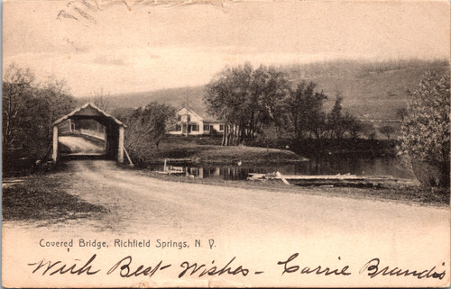 Undivided back postcard showing covered bridge and farmhouse at Richfield Springs New York with country road and trees.