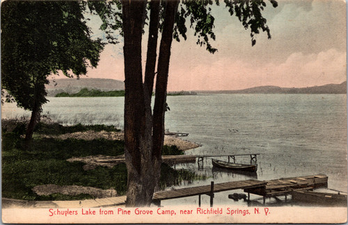Divided back postcard showing Schuylers Lake from Pine Grove Camp near Richfield Springs New York with rowboats, docks, and trees.