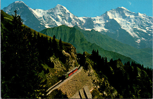 Vintage postcard showing the Schynige Platte Railway with Eiger Monch and Jungfrau mountains in Switzerland