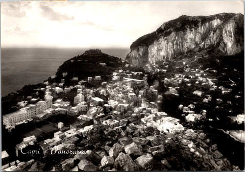 Vintage black and white postcard showing a panoramic view of Capri Italy with hillside town and coastline