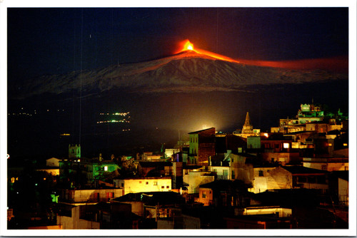 Night view postcard of Taormina Sicily with Mount Etna erupting and glowing lava in the background
