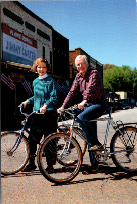 President Jimmy Carter and Rosalynn Carter riding bicycles on Main Street Plains Georgia postcard