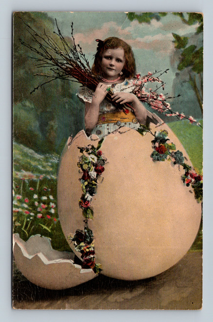 Antique Easter postcard showing girl standing in large egg shell holding spring blossoms
