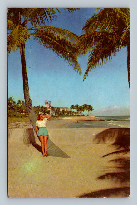 woman leanings against palm tree