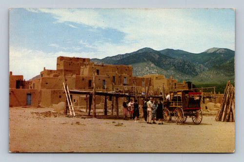 Tourists at Taos Pueblo viewing pottery, basket making, weaving, and painting