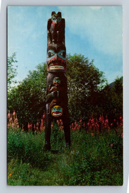 Hand carved totem pole in a field of Alaska Fireweed