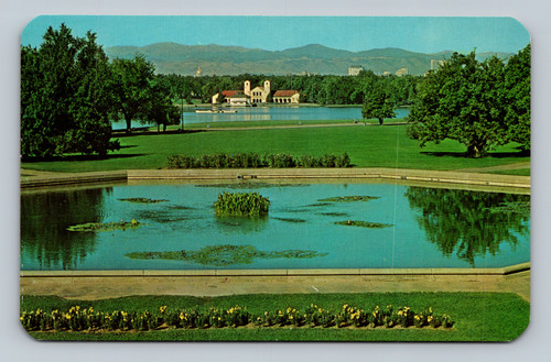 Bird's-eye view of City Park with lake, pavilion, and Rocky Mountains including Mount Evans in Denver