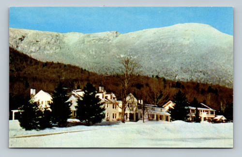 The Lodge at Smugglers Notch with snow clad Mt. Mansfield and ski trails in Stowe Vermont