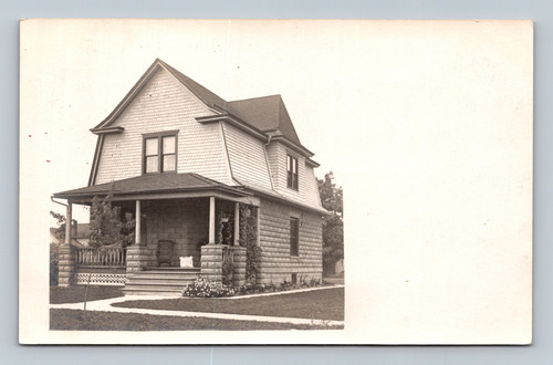 Antique RPPC postcard featuring large Victorian style house with wraparound porch