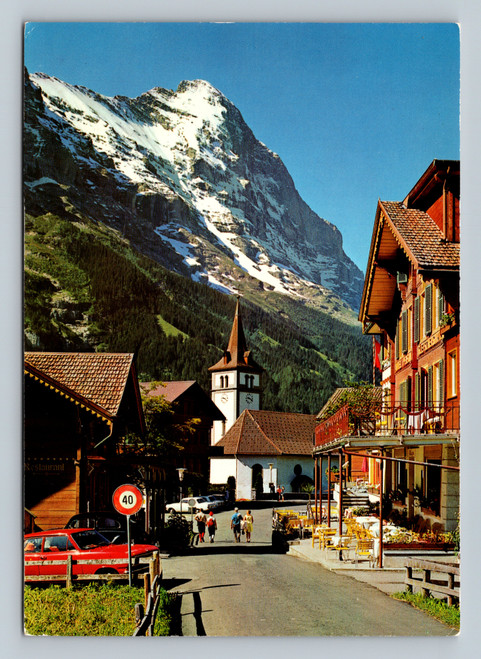 Church with Eiger mountain and mountain restaurant in Grindelwald Switzerland