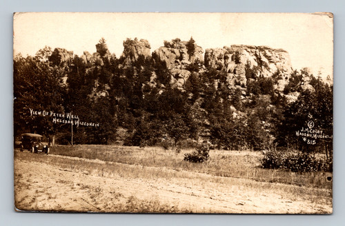 Real photo postcard showing Petenwell rock formations near Necedah Wisconsin with early automobile on roadway