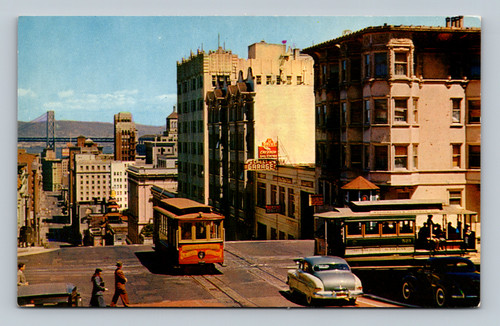San Francisco cable cars crossing at California and Powell Streets with Bay Bridge in distance