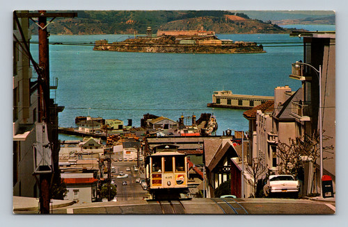 Cable car climbing Hyde Street Hill with Alcatraz and San Francisco Bay in the background