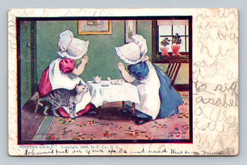 two girls having a tea party ssaying grace with kitten