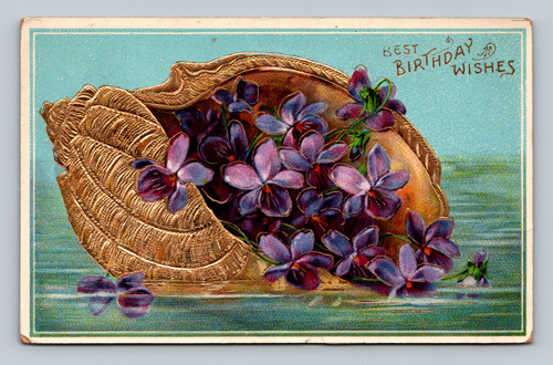 purple violets in gold sea shell