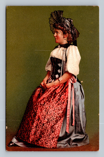 Vintage Swiss postcard showing a Bernese woman in traditional regional dress with red patterned skirt, black bodice, white puffed sleeves and elaborate hat against a green background.