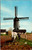Dutch windmill farmer horse plowing field