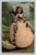 Antique Easter postcard showing girl standing in large egg shell holding spring blossoms