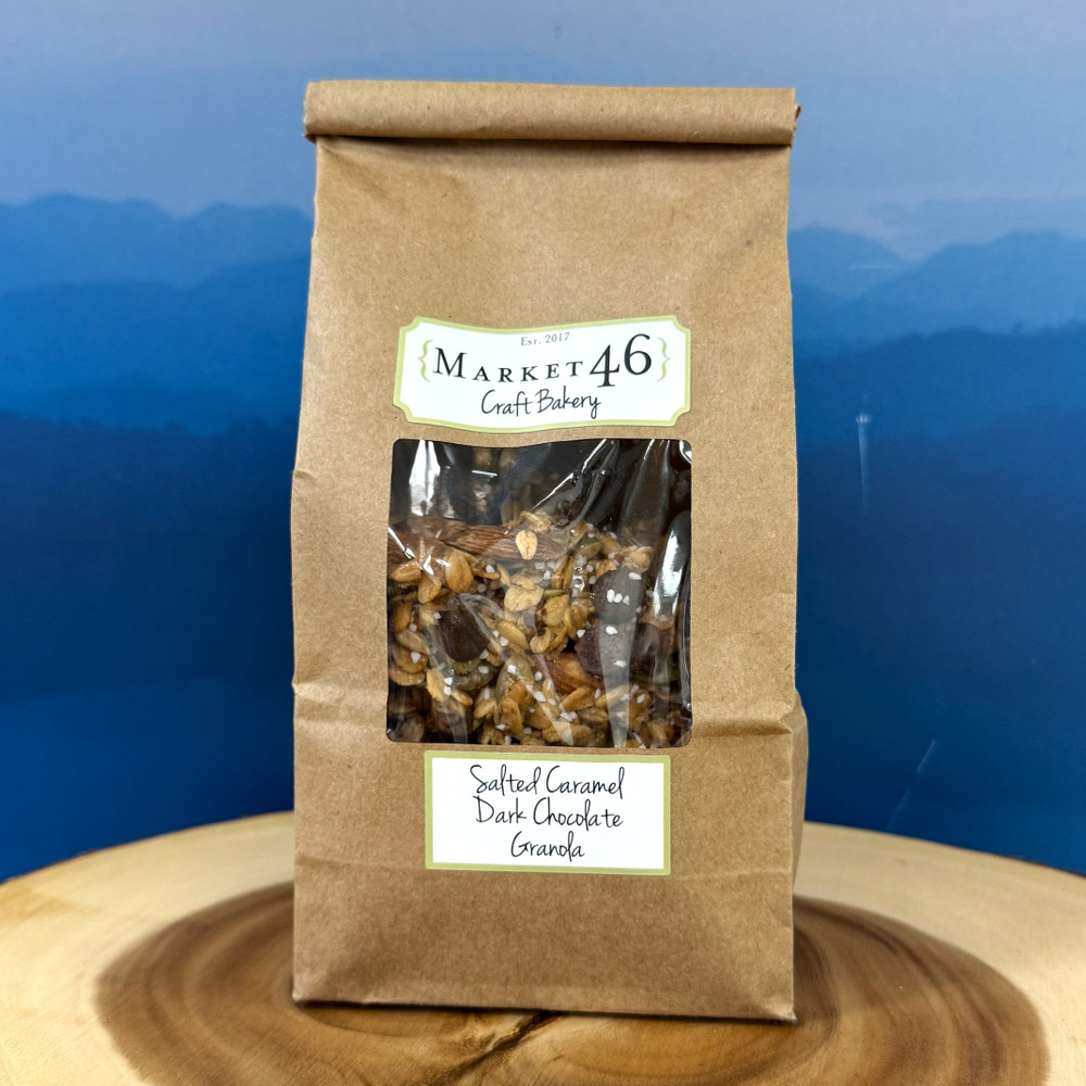 Salted caramel dark chocolate granola in a bowl with visible chocolate chunks, oats, almonds, and seeds, styled as a gourmet Alabama-made snack