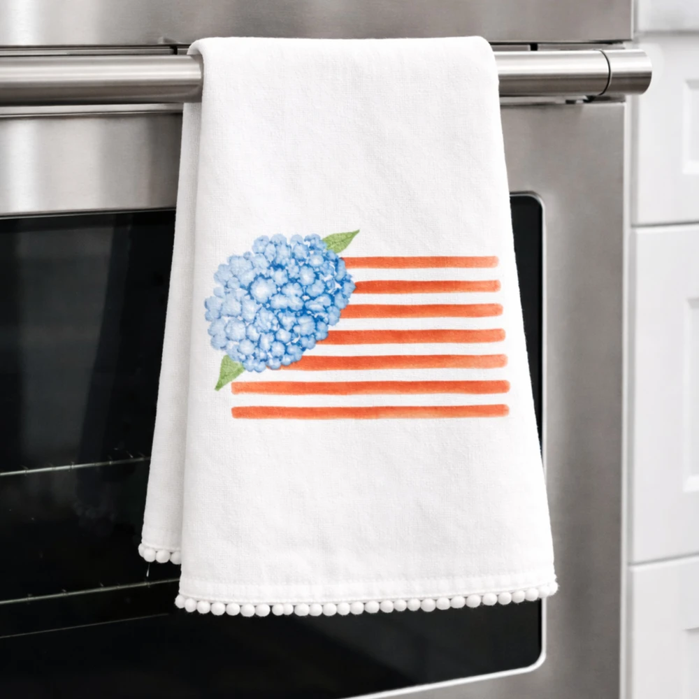 hydrangea flag tea towel with blue floral and red stripes, decorative kitchen towel with pom trim for summer and patriotic gifts