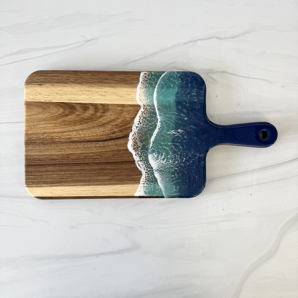 Ocean resin cutting board handcrafted from premium wood with blue coastal resin waves, displayed as a charcuterie and serving board made in Alabama.