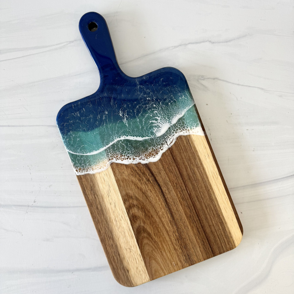 Ocean resin cutting board handcrafted from premium wood with blue coastal resin waves, displayed as a charcuterie and serving board made in Alabama.