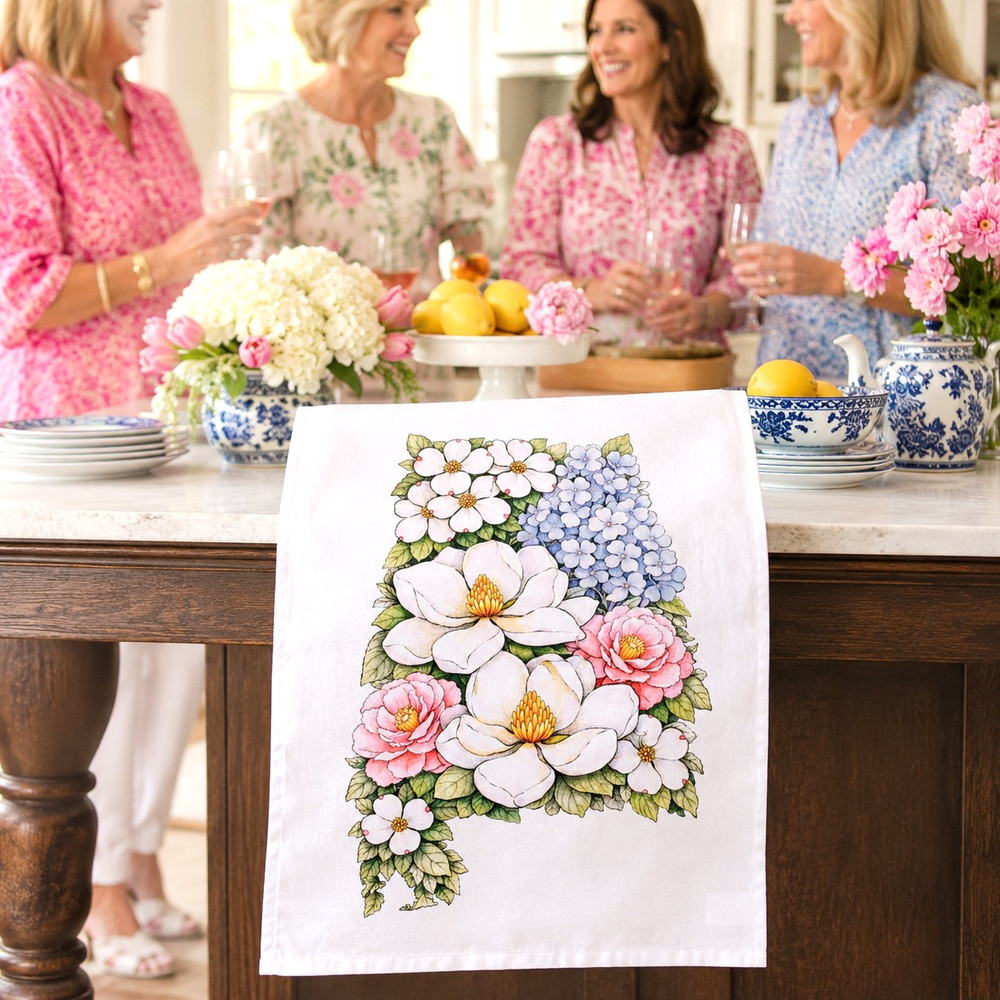 Alabama floral tea towel featuring magnolia, hydrangea, camellia, and dogwood artwork in the shape of Alabama on a decorative kitchen towel.