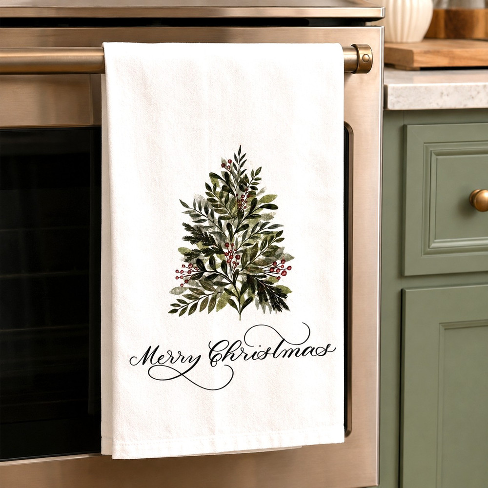 Holly tea towel with Merry Christmas script, made in Alabama, white cotton holiday kitchen towel with watercolor evergreen design for seasonal home décor.