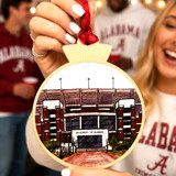 Bryant-Denny Stadium wooden ornament featuring detailed University of Alabama football stadium artwork, natural wood frame, and red hanging ribbon.